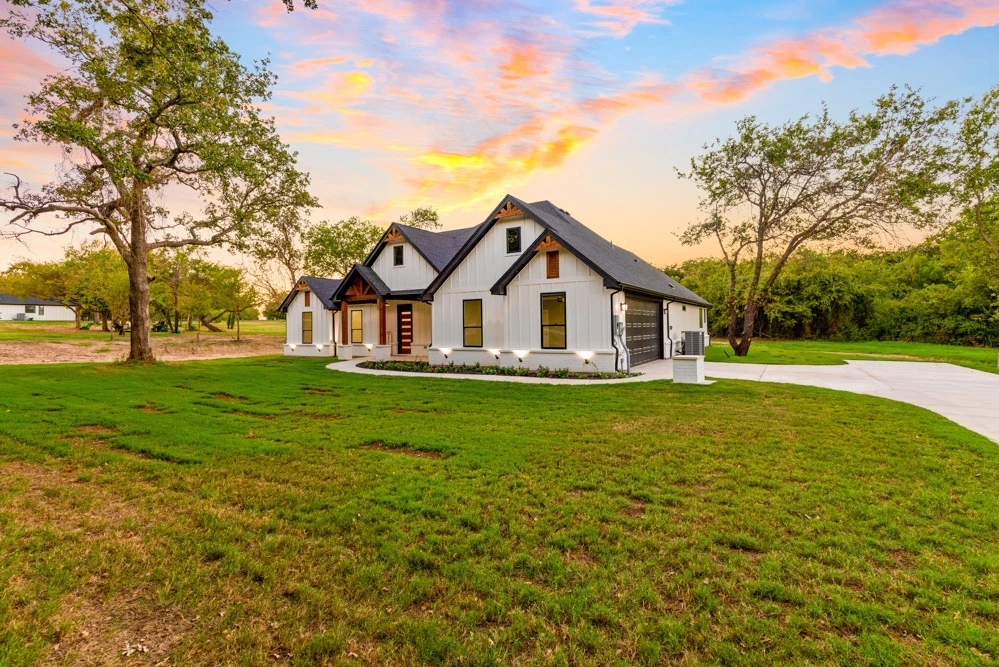 Широк изглед на къща с дървета и вечерно небе